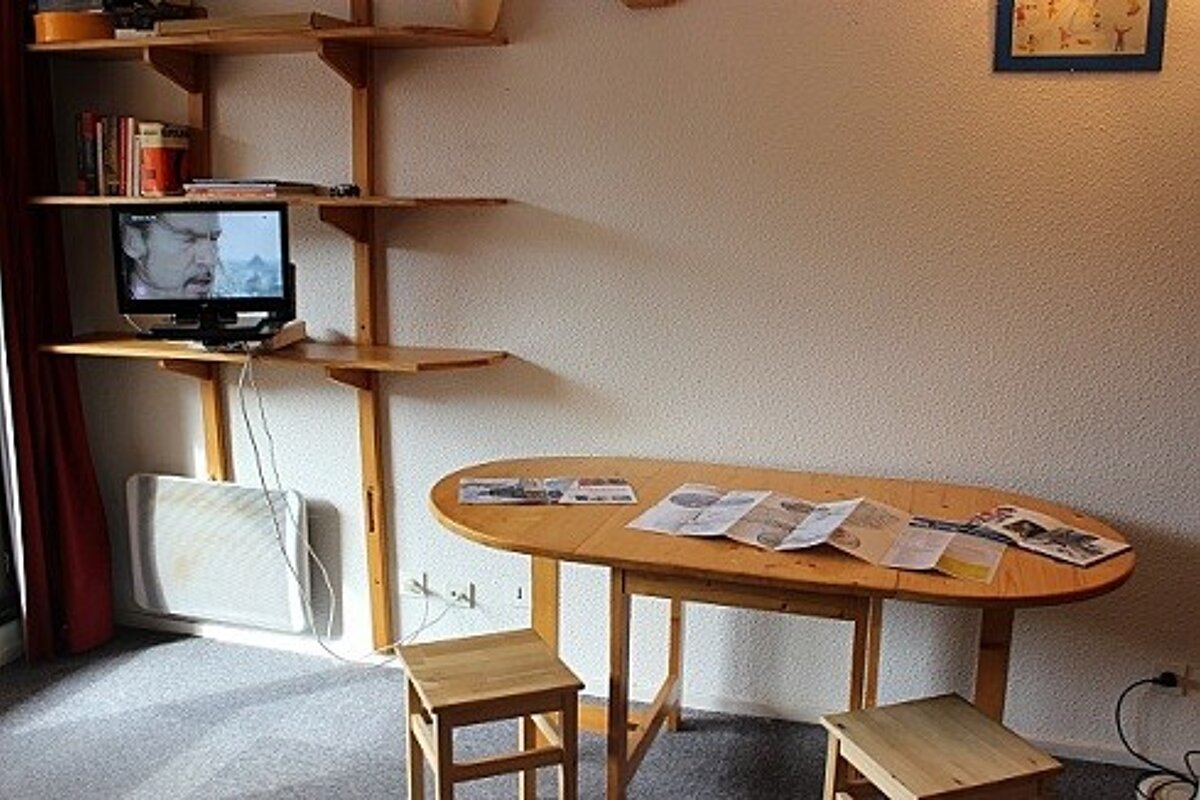 A wooden table with a tv on top of it