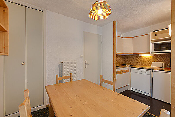 A kitchen with a wooden table and chairs