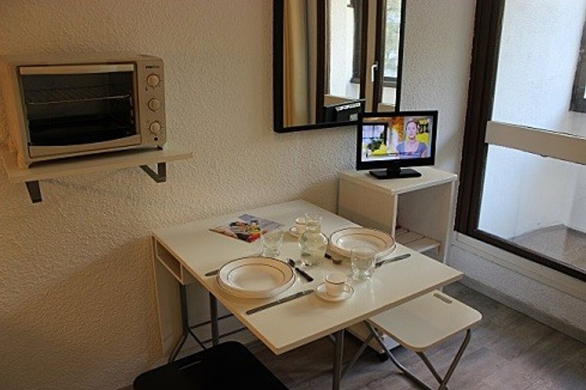 A small white table with plates and cups on it
