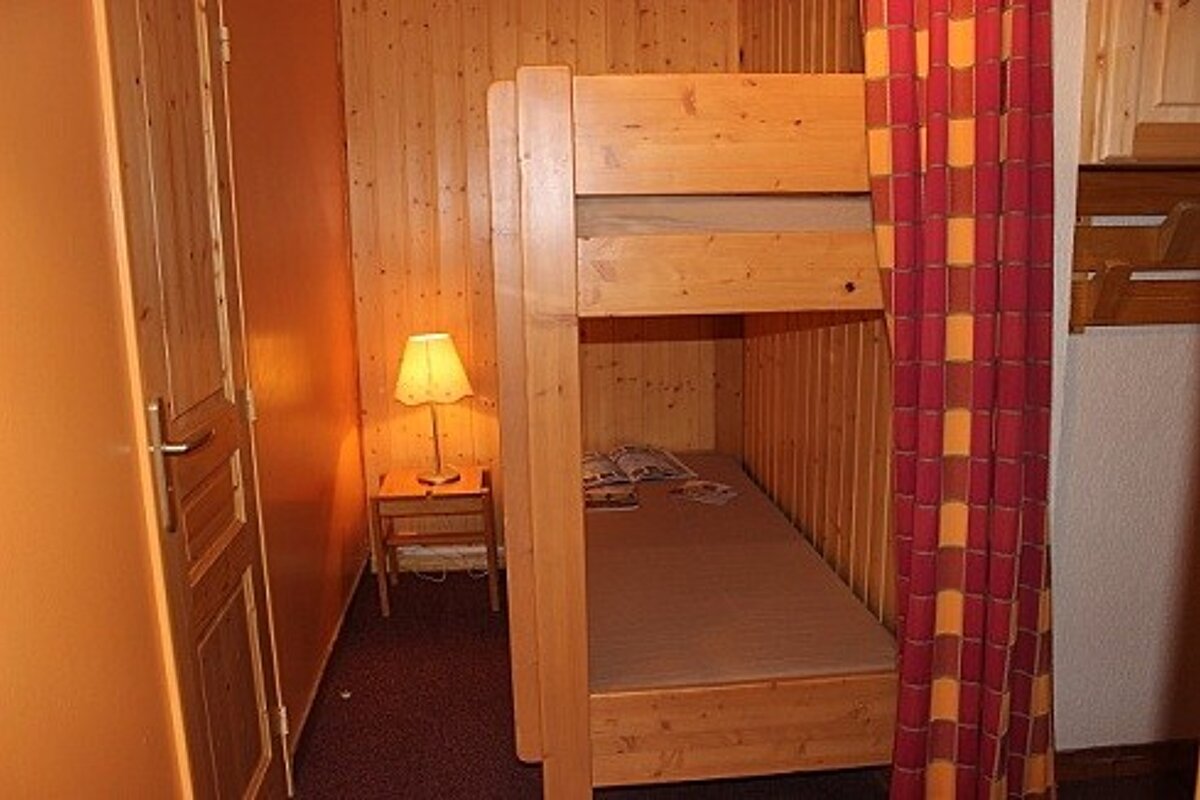 A bedroom with a bunk bed and a lamp