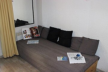 A couch with pillows and a magazine on it