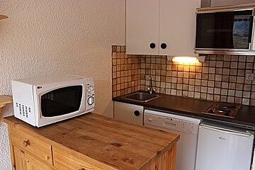 An lg microwave sits on a wooden counter in a kitchen