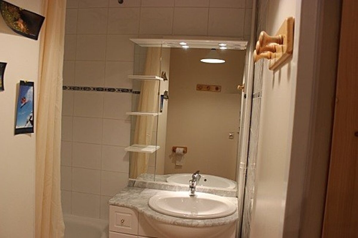 A bathroom with a sink and a large mirror