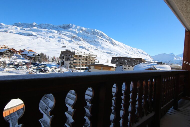 A balcony with a view of a snowy mountain range
