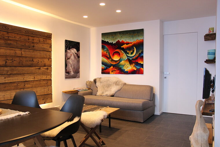 A living room with a couch and a painting on the wall