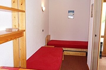 A bedroom with two beds and a wicker lamp
