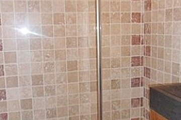 A bathroom with a walk in shower and a sink