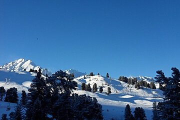 A snowy mountain with a blue sky in the background