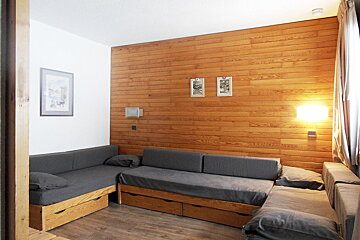 A room with a couch and a picture on the wall