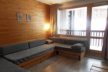 A living room with a couch and two pictures on the wall