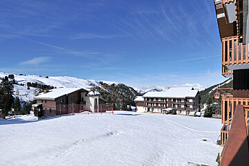 A snowy landscape with a few buildings in the background