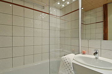 A bathroom with white tiles and a sink