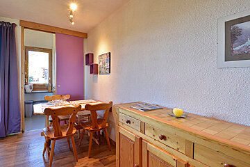 A room with a table and chairs and a picture on the wall