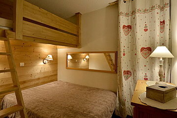 A bedroom with a bunk bed and a lamp