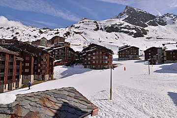 A snowy ski resort with a mountain in the background