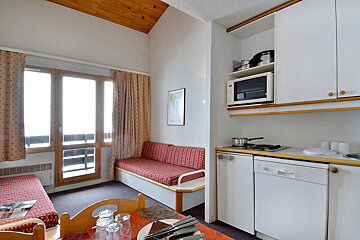 A kitchen with white cabinets and a microwave