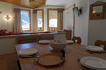 A wooden table with plates and a bowl on it