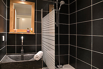 A bathroom with black tiles and a sink