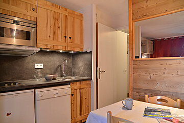 A kitchen with wooden cabinets and a stainless steel oven