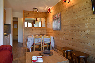 A living room with wood paneling and a table and chairs