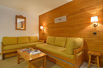 A living room with a couch and a mirror