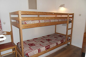 A bunk bed with a red and white striped mattress
