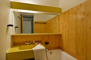 A bathroom with a yellow sink and a bathtub