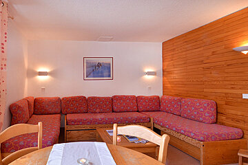 A living room with a picture on the wall above the couch