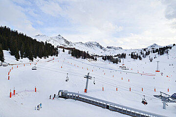 A ski lift going up a snow covered mountain