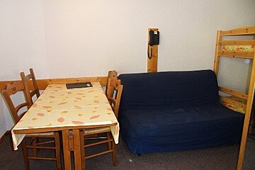 A room with a table and chairs and a bunk bed