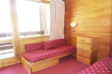 A wooden room with a couch and a dresser