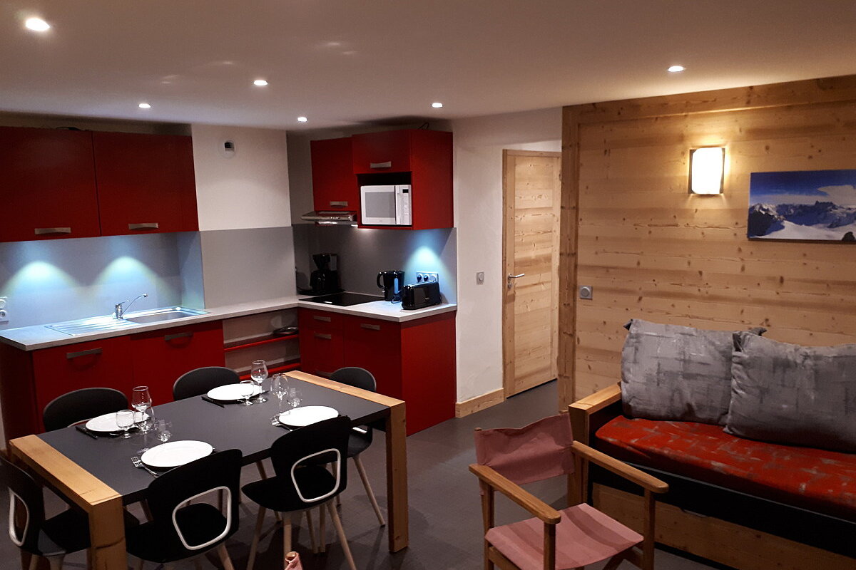 A kitchen with red cabinets and a microwave