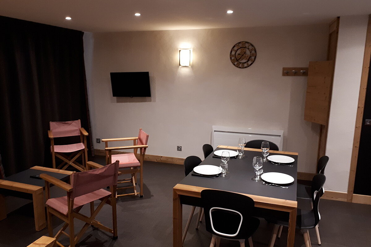 A room with a table and chairs and a clock on the wall