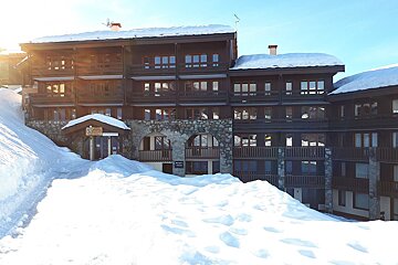 A snowy building with a sign that says ' altitude ' on it