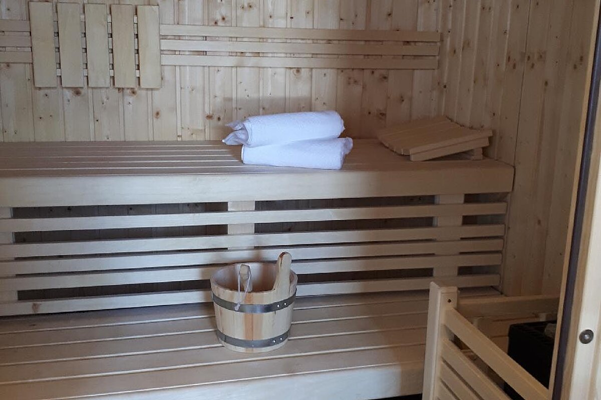 A wooden sauna with a bucket on the bench
