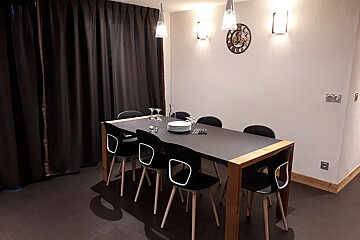 A clock hangs above a dining room table