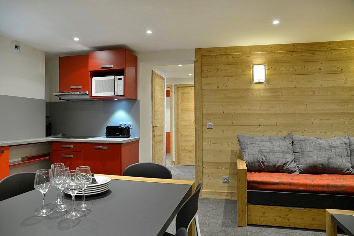A kitchen with red cabinets and a microwave