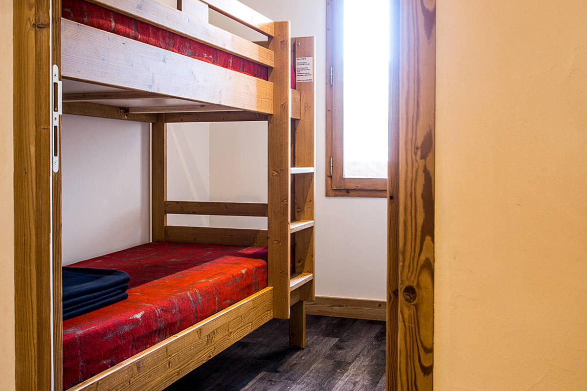A bunk bed with a red blanket on it
