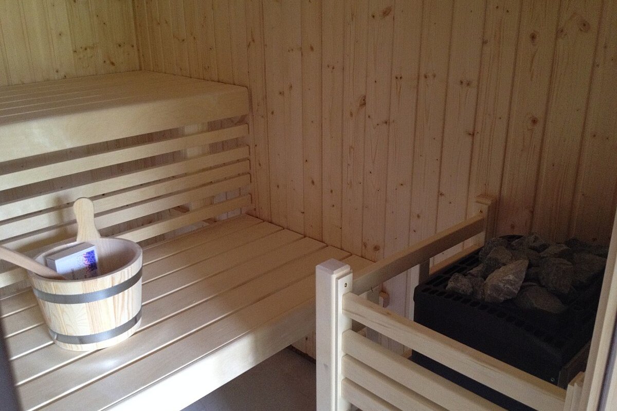 A wooden bucket sits on a wooden bench in a sauna