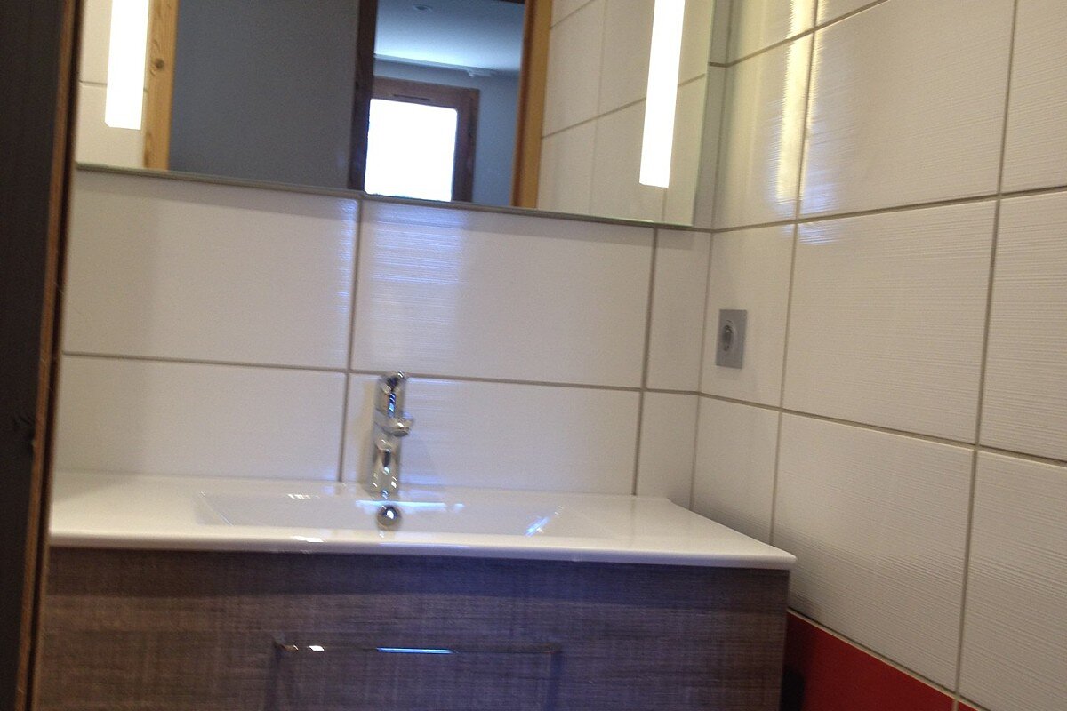 A bathroom with red and white tiles and a sink