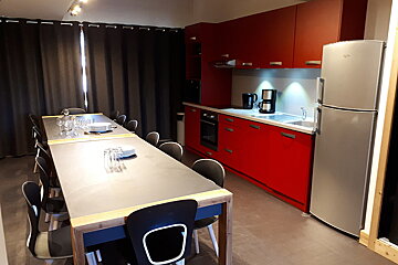 A kitchen with red cabinets and a whirlpool refrigerator