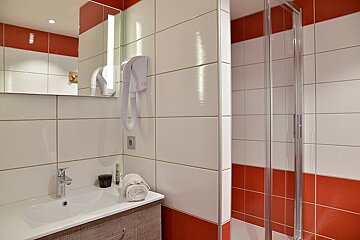 A bathroom with red and white tiles and a sink