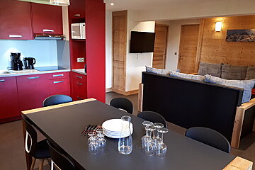 A dining table with plates and wine glasses on it