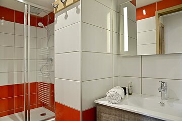 A bathroom with red and white tiles and a sink
