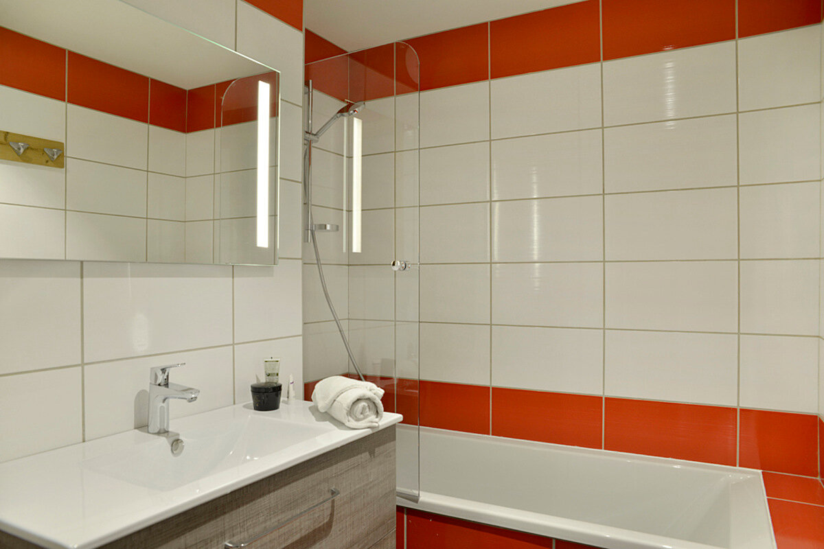 A bathroom with red and white tiles and a sink