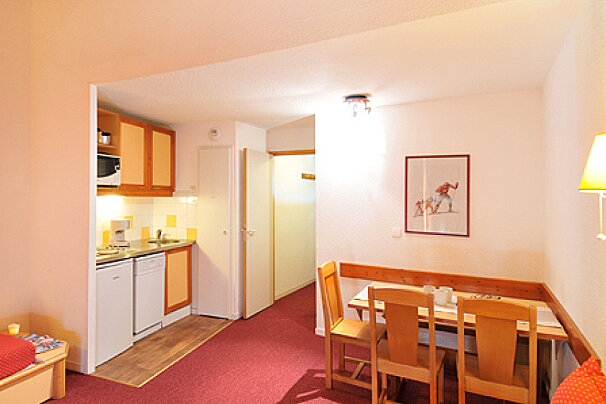 A kitchen with a picture of skiers on the wall