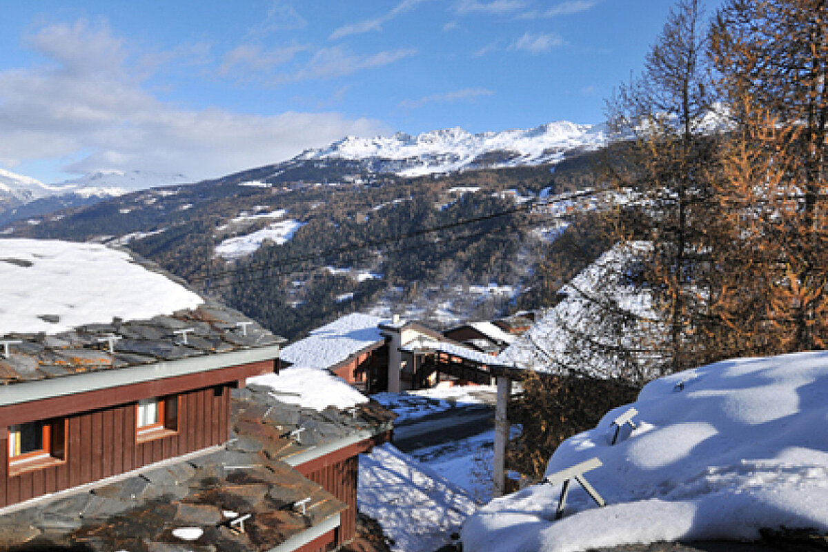 A snowy landscape with mountains in the background