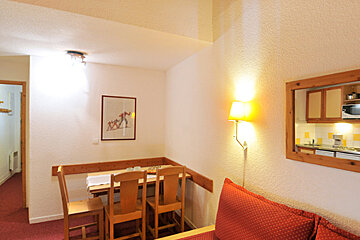 A room with a table and chairs and a picture on the wall