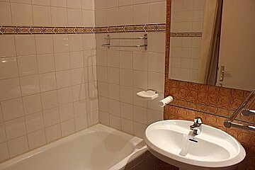 A bathroom with a sink , bathtub and mirror
