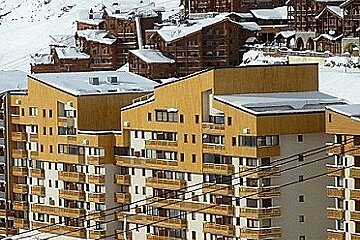 A ski resort with a lot of buildings covered in snow